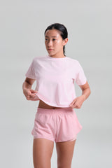 Front view, hands at the hem, KYDRA Cross Back Tee in Pink #color_Pink