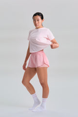 Side view in movement, KYDRA Cross Back Tee in Pink #color_Pink