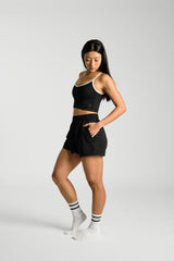 Three quarter angle, in movement, hand in the side pocket, KYDRA Kara Flex Shorts in Black #color_Black