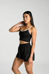 Close front view of the adjustable straps and neckline, KYDRA Lexa Longline Bra in Black #color_Black