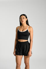 Front view, cropped at the hip, KYDRA Lexa Longline Bra in Black #color_Black