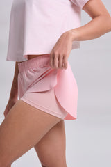 Close view of the pleated outer layer lifted to show the inner liner, KYDRA Pleated Shorts in Pink #color_Pink